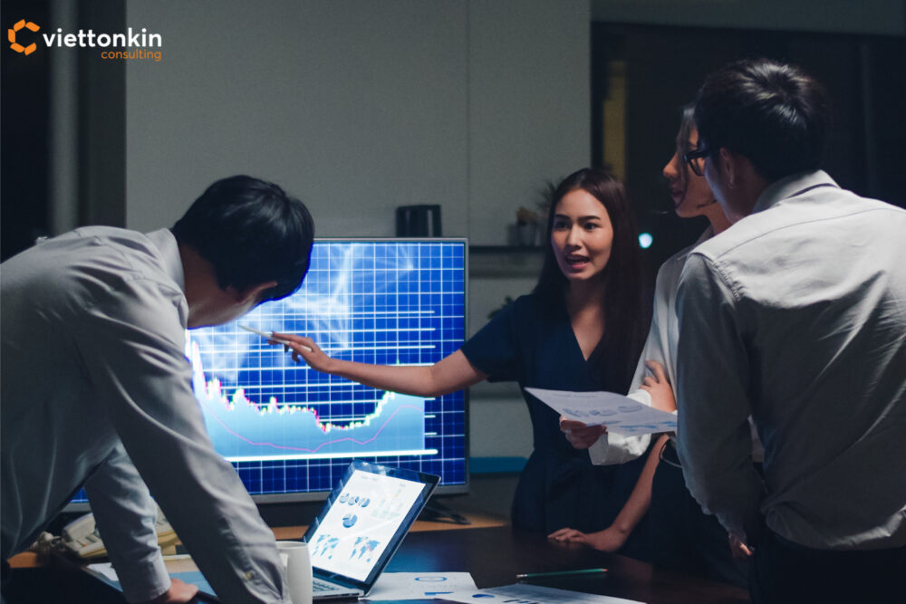 Đội ngũ kinh doanh brainstorming và phân tích dữ liệu thị trường trên màn hình, tượng trưng cho kế hoạch chiến lược và lộ trình thành công cho doanh nghiệp dược phẩm Việt Nam